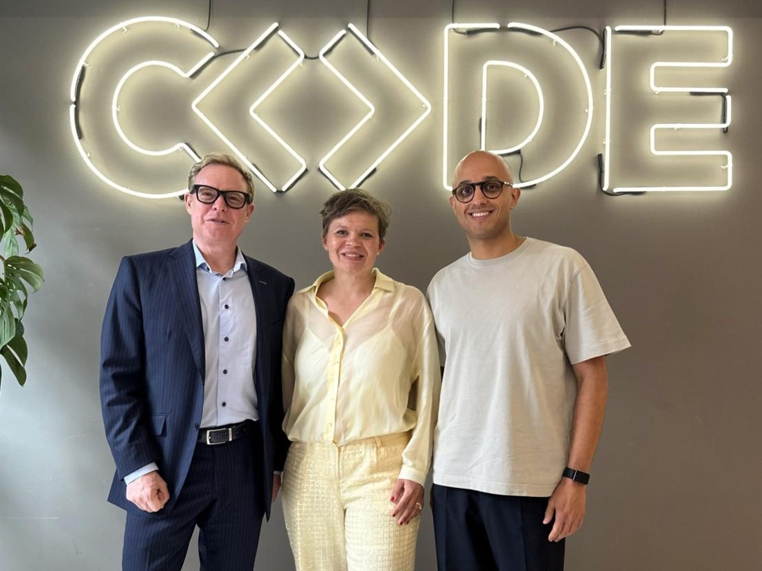 Stephan Schambach, Prof. Dr. Julia Köhn and Younes Ouaqasse in front of the CODE neon sign